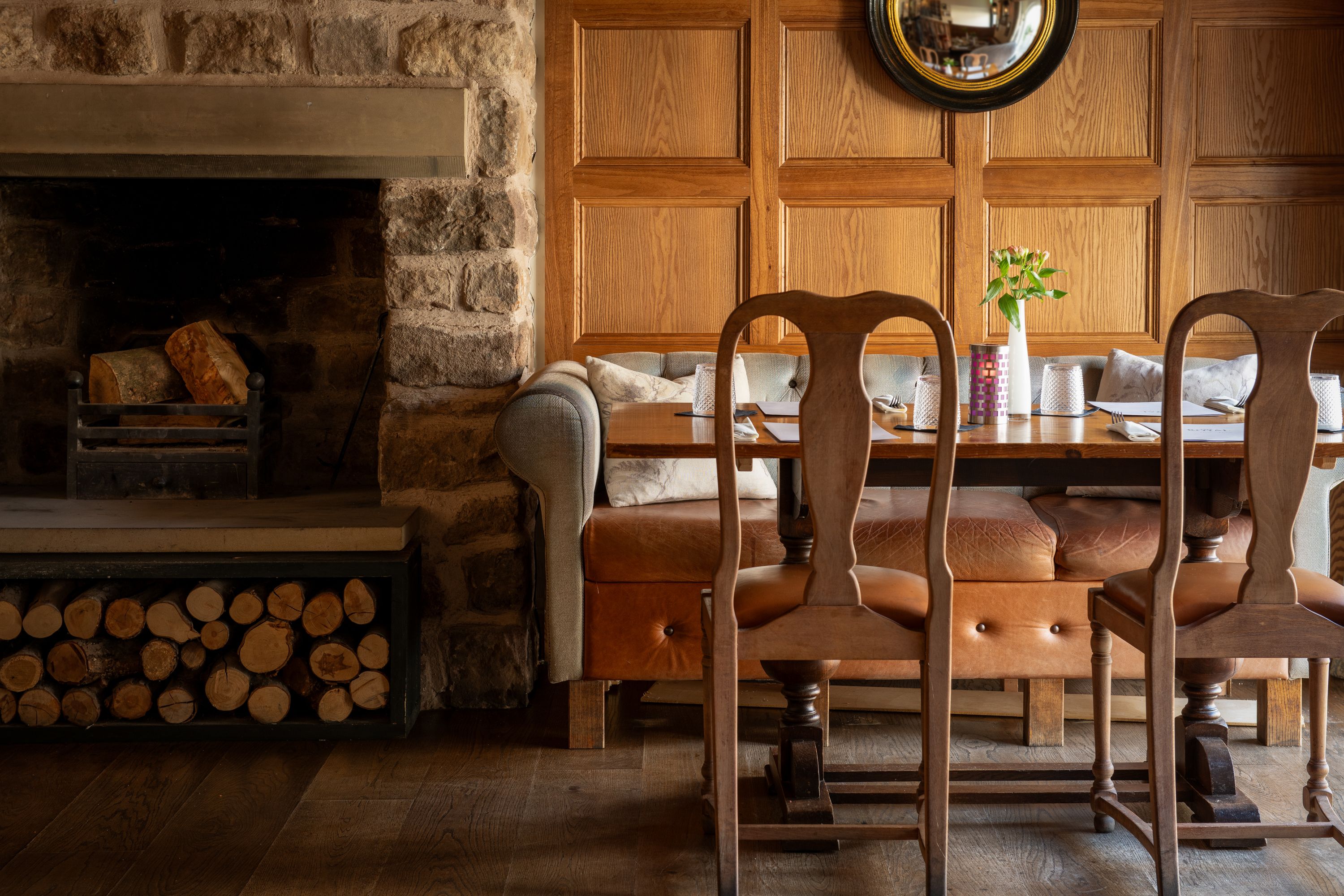 a restaurant table next to an open fire with large sofa