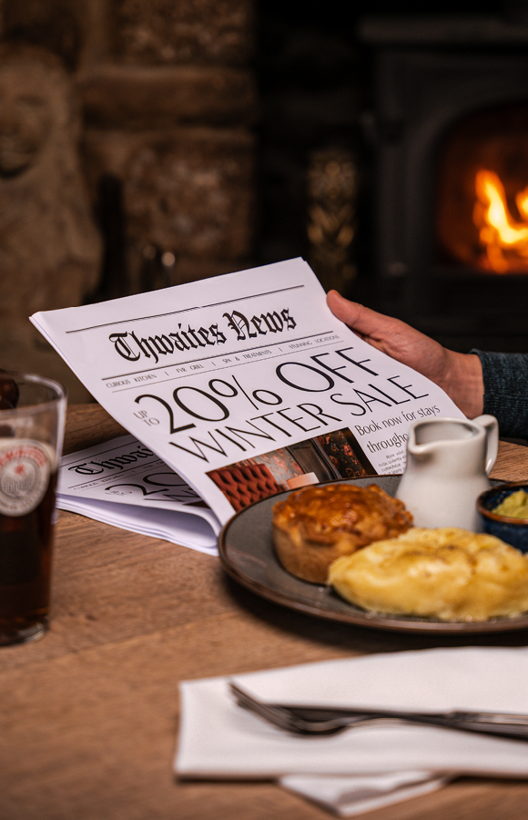 "up to 20% off this winter" newspaper with pie and a pint at a pub table